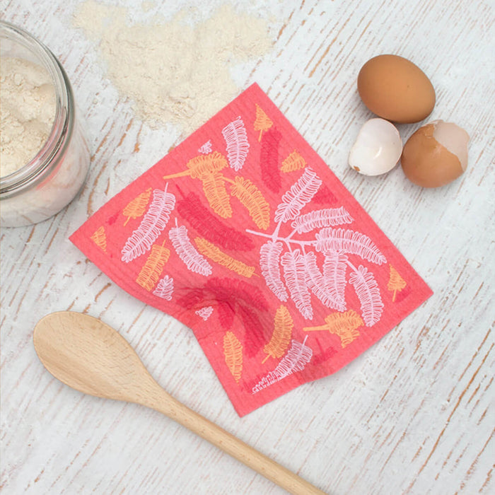 Compostable sponge cloth with a poinciana design on a bench.