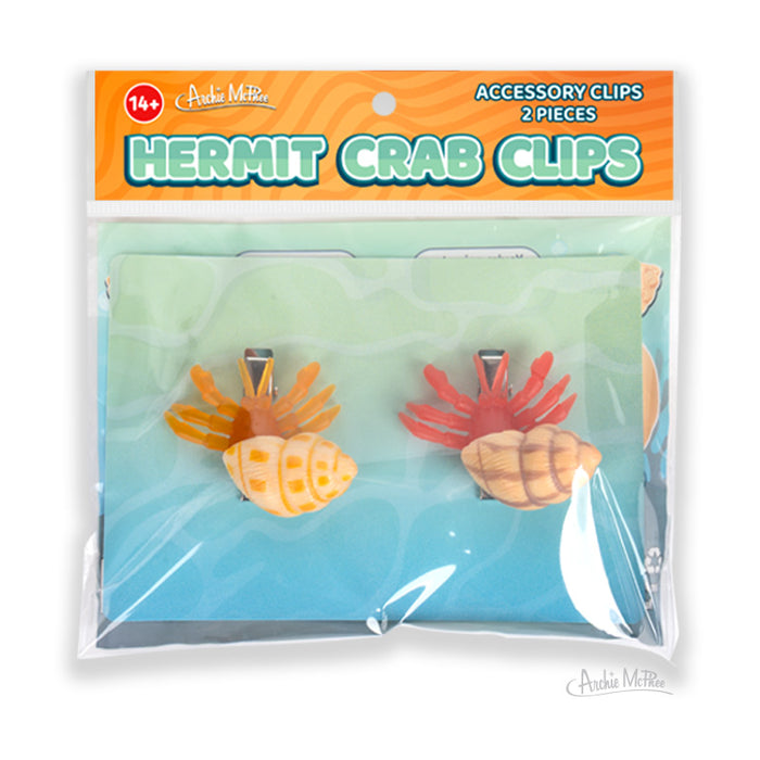 Two colorful hair clips shaped like hermit crabs, packaged as Hermit Crab Hair Clips—these playful vinyl accessories bring a whimsical touch to any hairstyle.