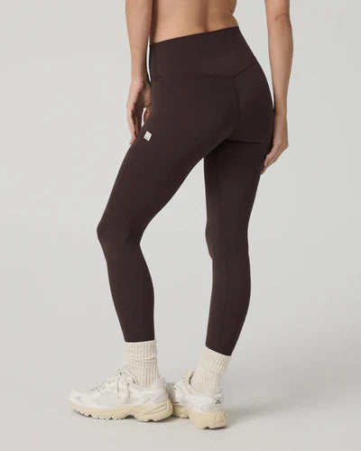 Person Vuori - AllTheForm Leggings with a small Vuori logo on a light gray background