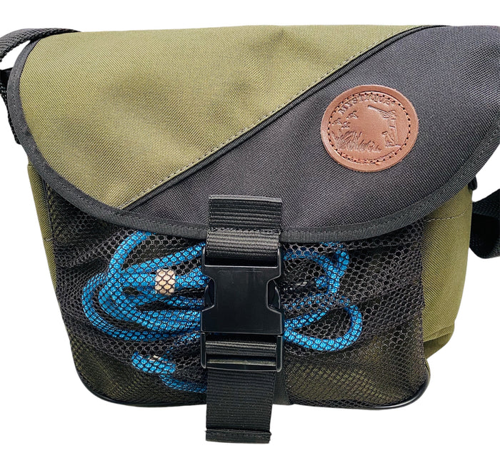 Green and black bag with a blue braid slip lead and leather patch on a white background