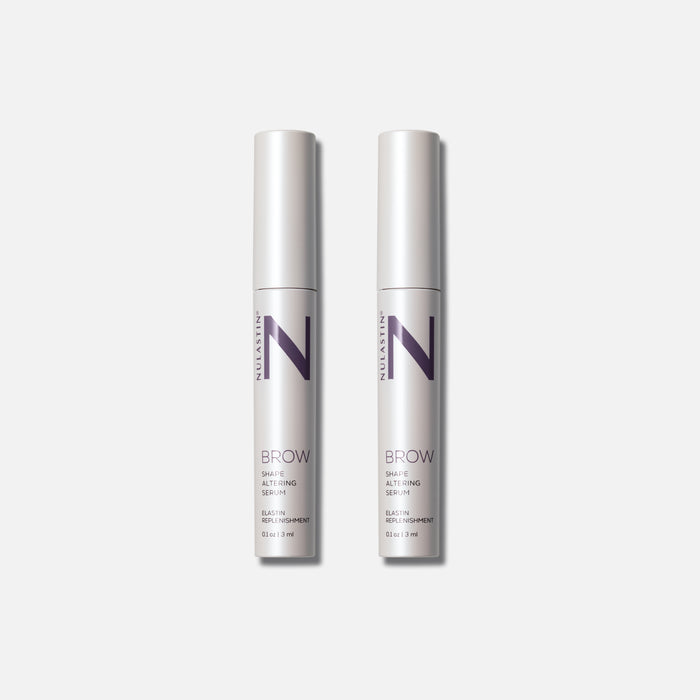 Front view of a pair of Brow Shape Altering Serum tubes showing NULASTIN N logo on slim silver tubes on gray background