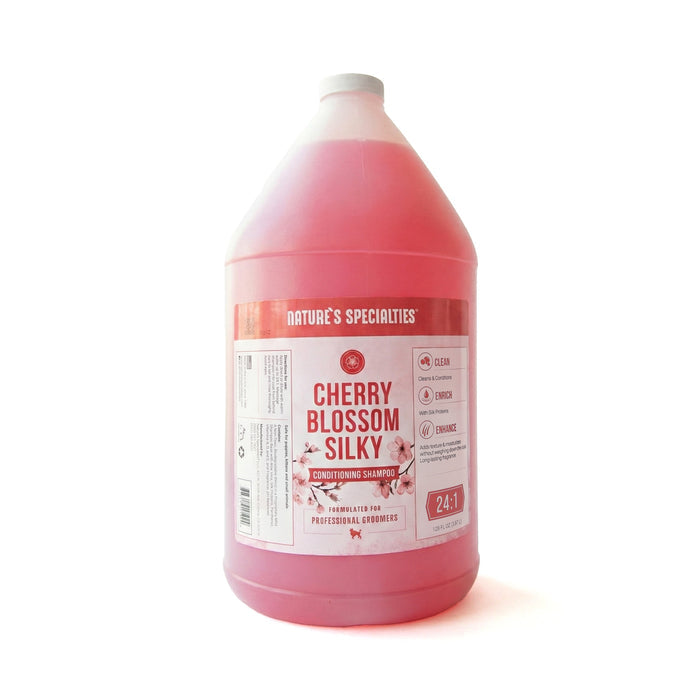Pink bottle of 'Cherry Blossom Silky' shampoo with a label on a white background