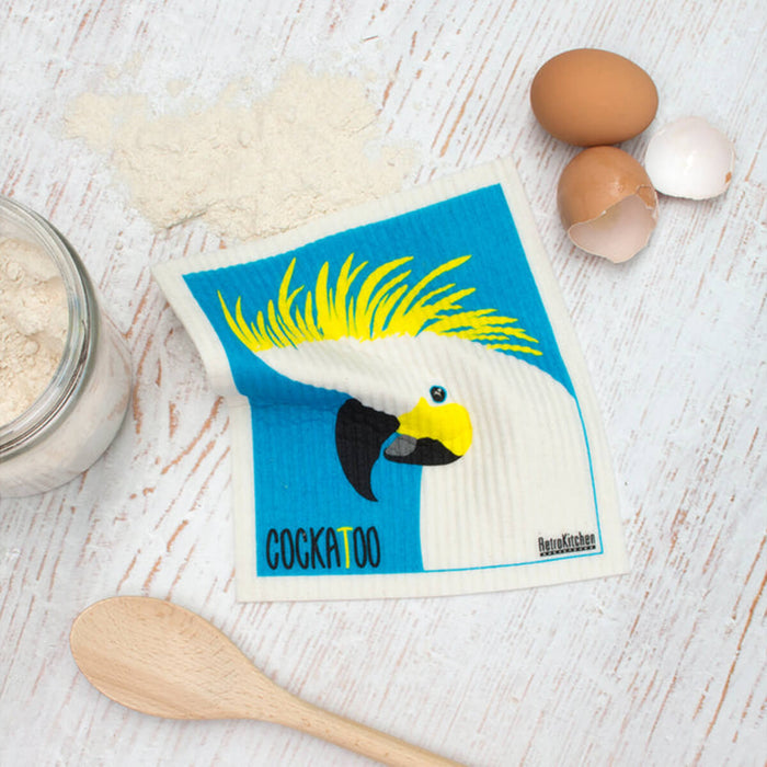 Compostable sponge cloth with a cockatoo design on a bench.