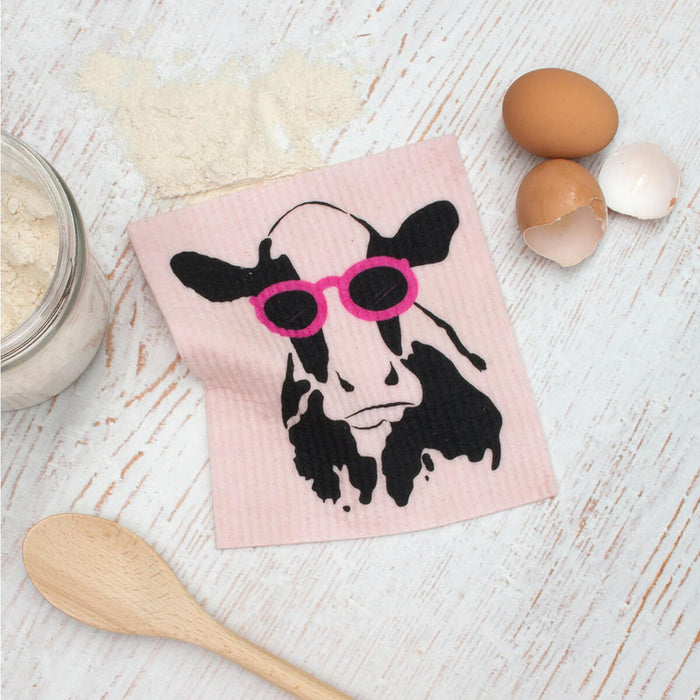 Compostable sponge cloth with a cow design on a bench.