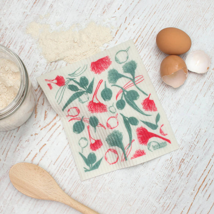 Compostable sponge cloth with a gumnut design on a bench.