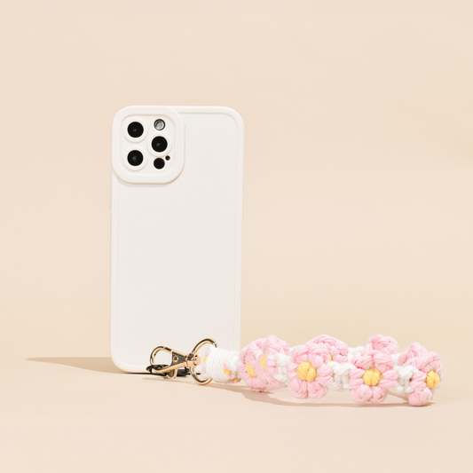 Pink crochet daisy phone strap bundle by Coconut Lane on a white smartphone with a white case.