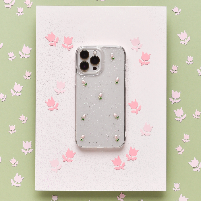 Clear phone case with pink tulip pattern and pearl accents, shown on white paper with pink floral decorations.