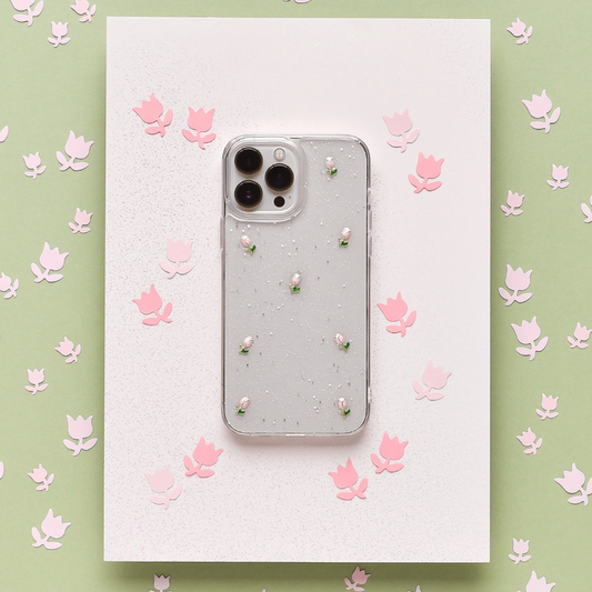 Clear phone case with pink tulip pattern and pearl accents, shown on white paper with pink floral decorations.