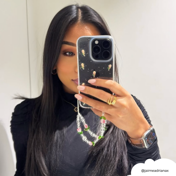 Woman with long dark hair holds a phone in a clear case with tulip pattern, coordinated with her black top.