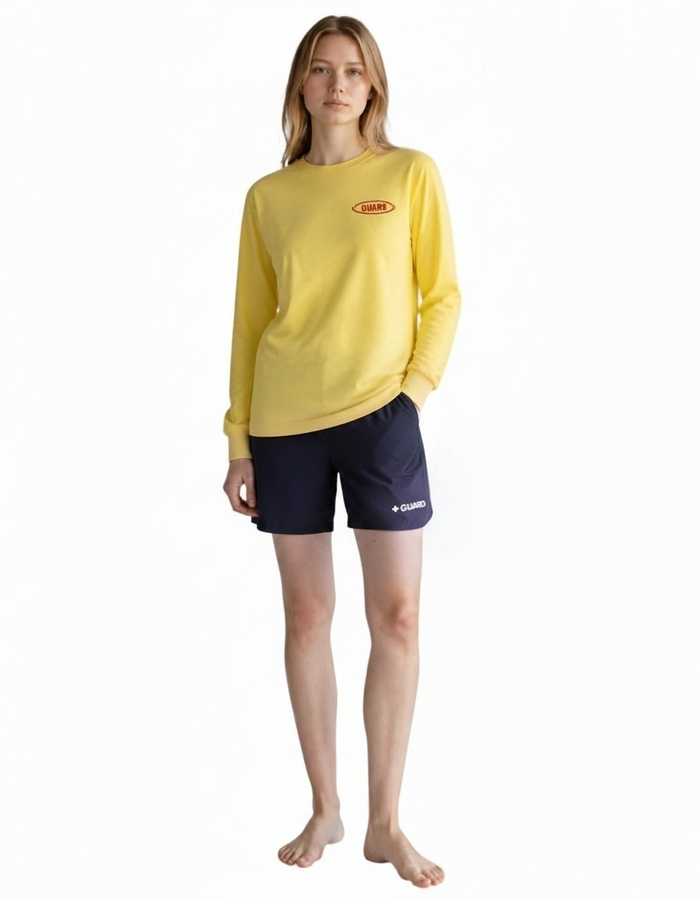 The Lifeguard Store yellow long sleeve Dri-Fit guard shirt worn by a model with navy blue lifeguard shorts.