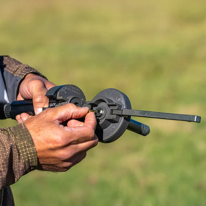 Close-up of hands holding a launcher against a blurred green background