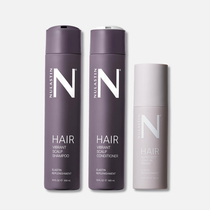Front view of Elevated Essentials Trio hair set showcasing two tall purple shampoo and conditioner bottles and a shorter pale leave-in primer on light gray background