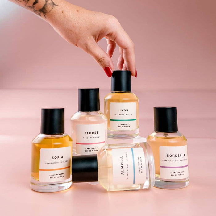 Collection of ECO. Modern Essential natural perfume bottles with visible labels on a pink background.