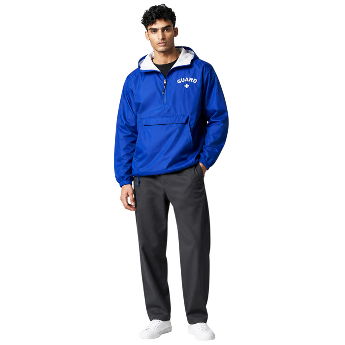 Male model wearing The Lifeguard Store blue nylon pullover jacket with Guard logo, hood, and ash heather lining.