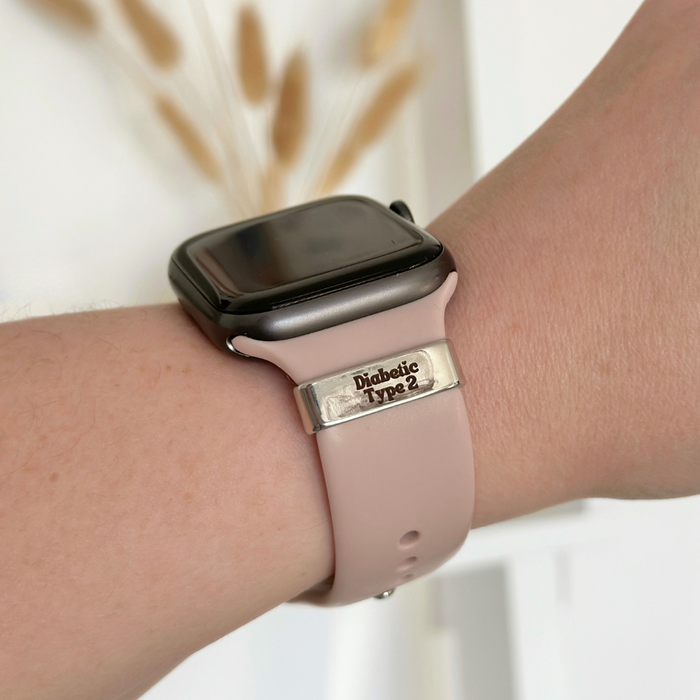 Silver Diabetic Type 2 medical charm attached to a pink smartwatch strap.