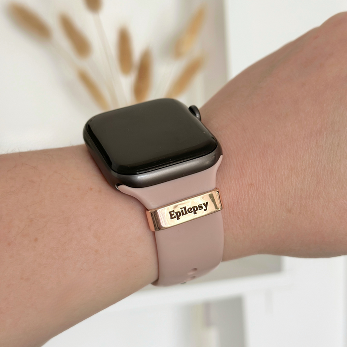Gold Epilepsy medical charm attached to a pink smartwatch band.