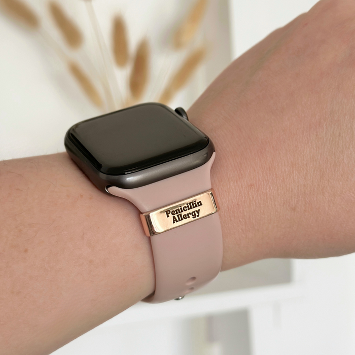 Gold Coconut Lane medical watch strap charm reading Penicillin Allergy on a pink smartwatch band.