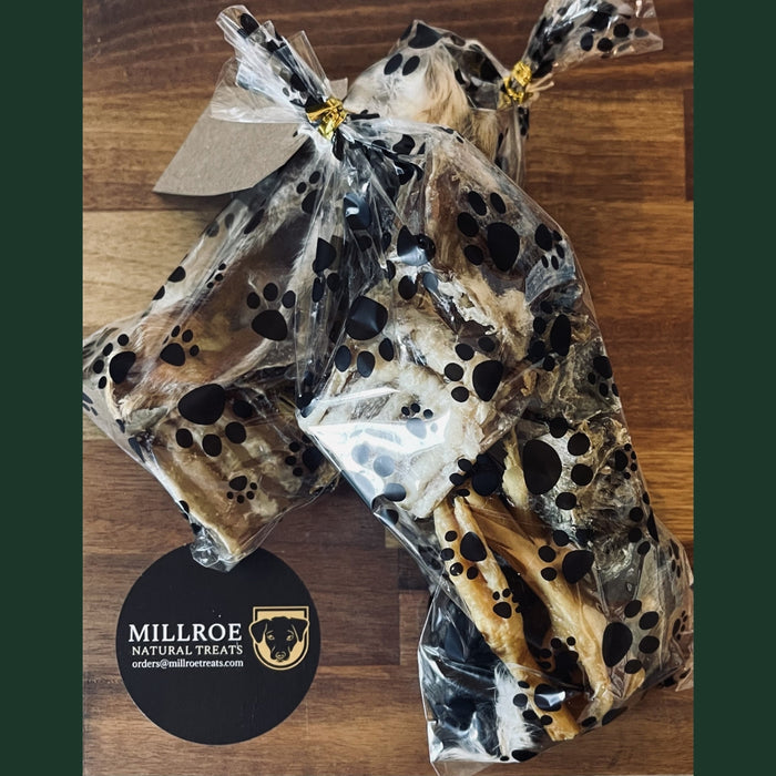 Dog chew treat in clear packaging on a wooden surface with Millroe Natural Treats branding.