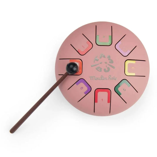 Pink circular musical instrument with colorful notations and a stick on a white background
