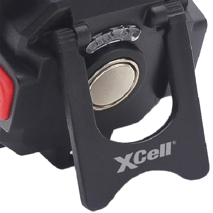 Close-up of a black metal component with a red button and 'XCell' branding on a white background.