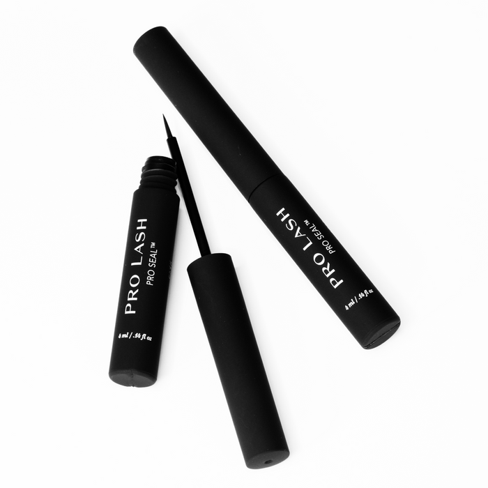 Eyelash extension sealant shown with open and closed Pro Lash Pro Seal tubes in matte black, featuring fine-tip applicator on white background
