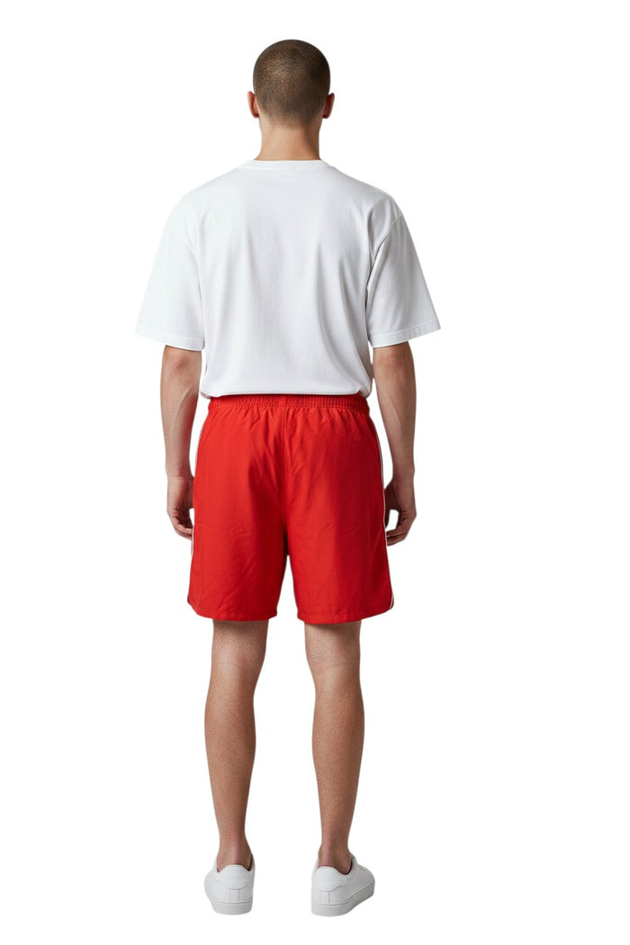 The Lifeguard Store red nylon lifeguard trunks with elastic waistband, drawstring, side pockets, and GUARD logo on left leg.