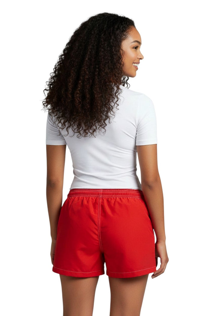 The Lifeguard Store women's red polyester-spandex board shorts with white contrast stitching and Guard logo.