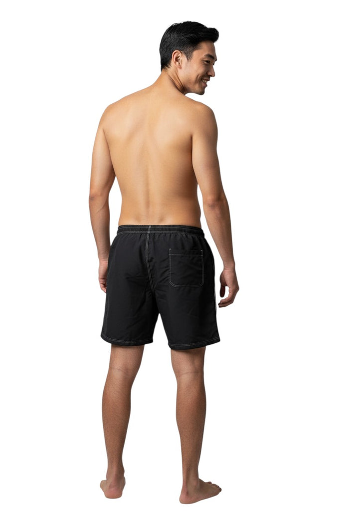 The Lifeguard Store black polyester-spandex blend boardshorts with white drawstring, contrast stitching, and GUARD logo.