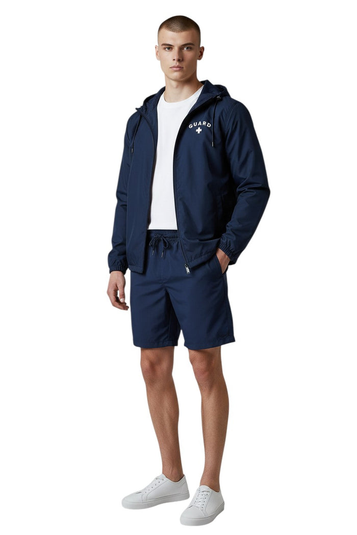 The Lifeguard Store navy blue waterproof jacket with "GUARD" lettering and a white cross on the chest.