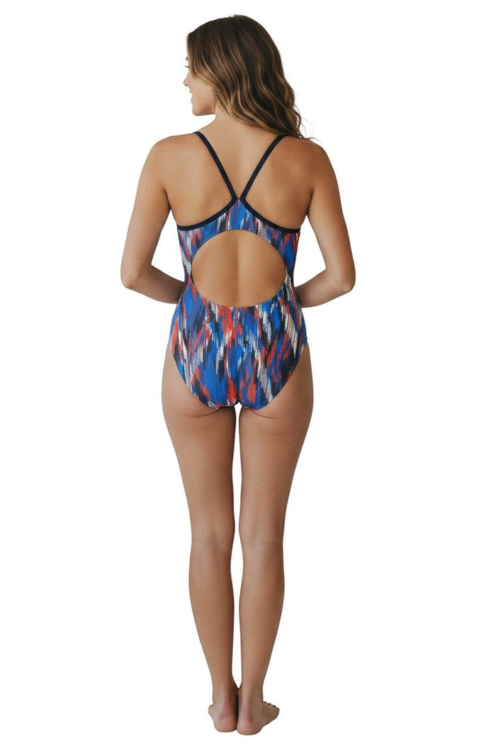 The Lifeguard Store RISE Sandies female shockwave swimsuit with blue, orange, and white abstract pattern. Features navy straps and back.
