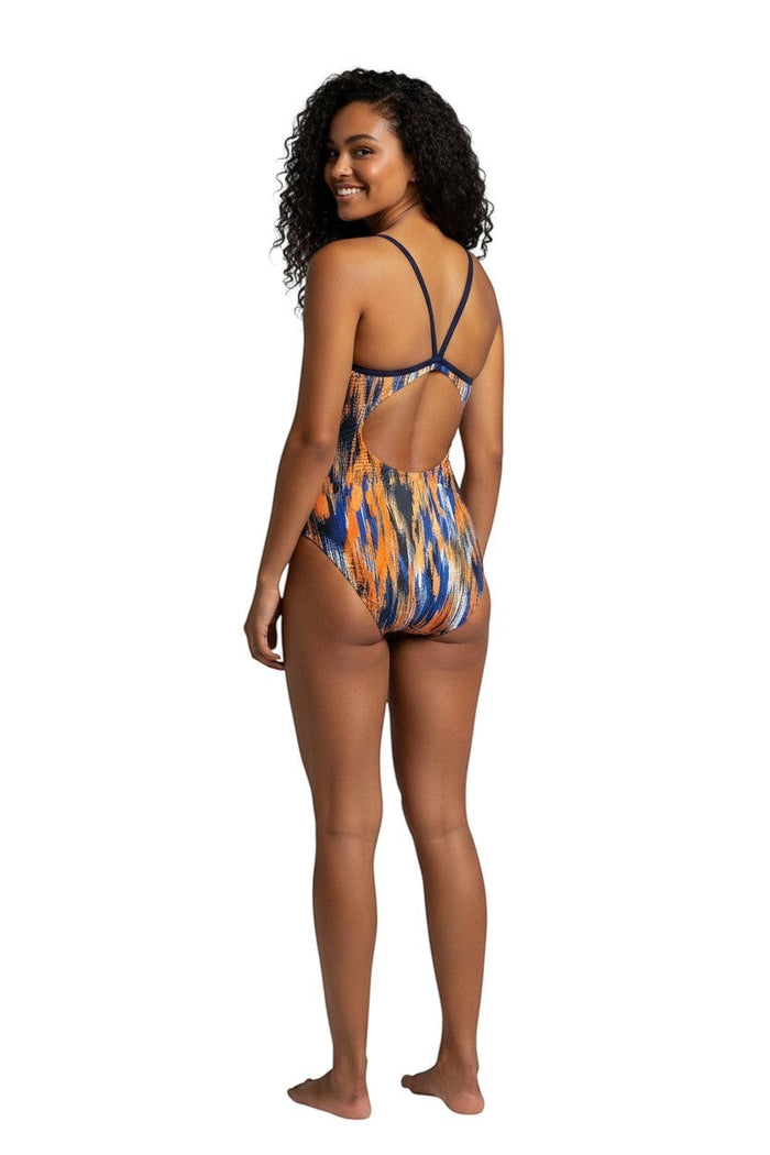 The Lifeguard Store RISE Sandies female shockwave poly swimsuit with orange, blue, and black abstract print and navy blue back.