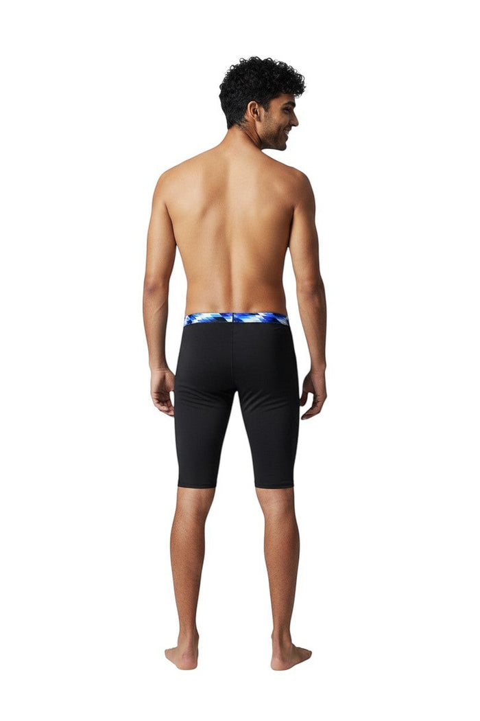 The Lifeguard Store RISE Sandies Swerve Poly Jammer swimsuit in black with a blue geometric waistband. Made of 91% Polyester/9% Spandex.
