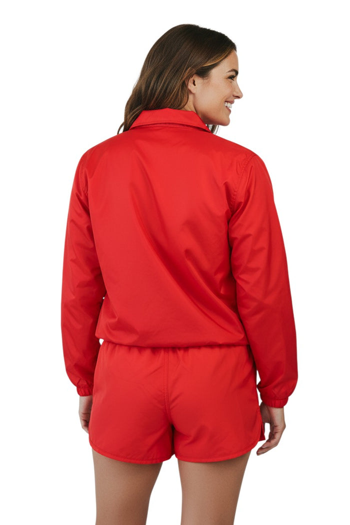 The Lifeguard Store RISE Solid Waterproof Jacket in red, made of polyurethane with heat-sealed seams and adjustable hood.