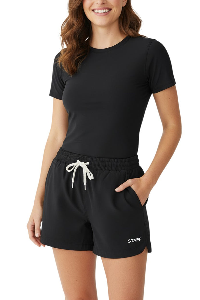 The Lifeguard Store black polyester roll short with elastic waistband, drawstring, and "STAFF" print. Quick-dry fabric.
