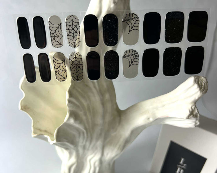Black Widow gel nail wraps displayed on a nail tree