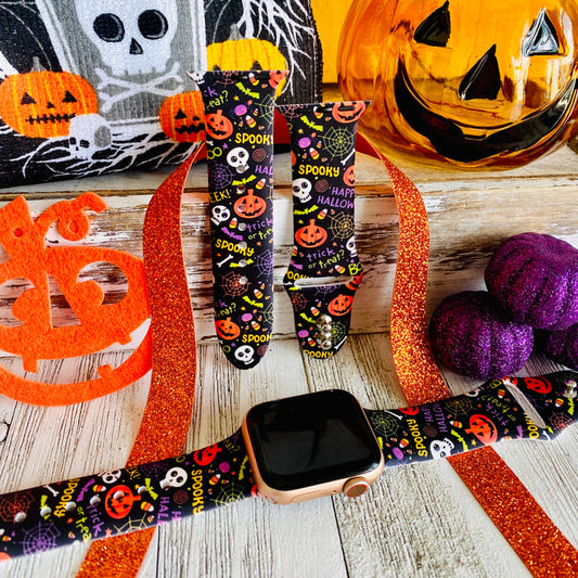 Spooky silicone Apple Watch band hero shot in black with orange pumpkins, white skulls and spiderwebs, shown with a rose gold Apple Watch.