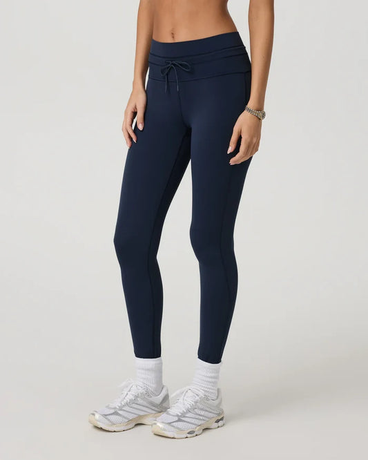 Person wearing navy Vuori - Daily Form Leggings on a light gray background