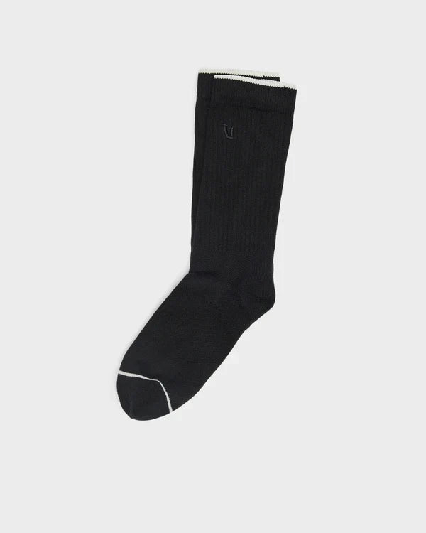 Black Vuori V1 Crew Sock with white trim on a light gray background