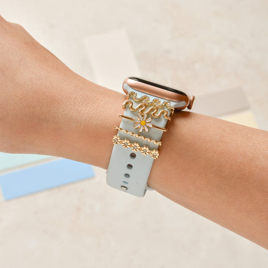 Gold wavy daisy Coconut Lane watch strap charms on a smartwatch, displayed against a beige background.