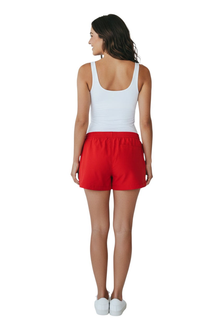 The Lifeguard Store red polyester shorts with elastic waistband, drawstring, and YMCA instructor logo. Quick-dry fabric.